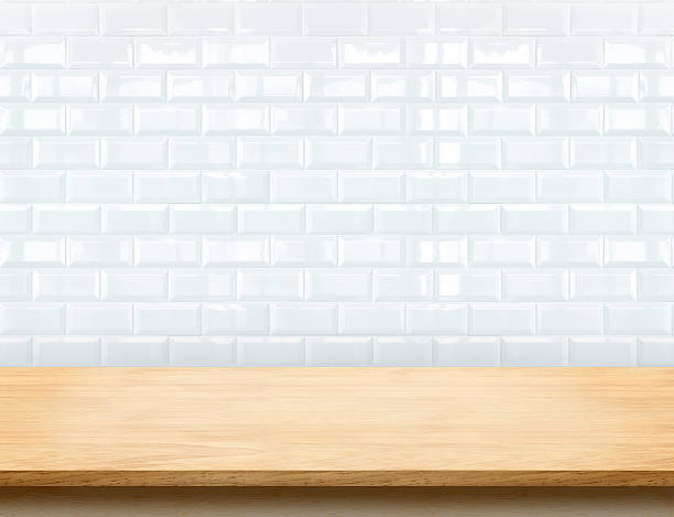 Empty beige wood table top with glossy white tile wall Empty beige wood table top with glossy ceramic white tile wall,Mock up for display or montage of product. kitchen worktop stock pictures, royalty-free photos & images