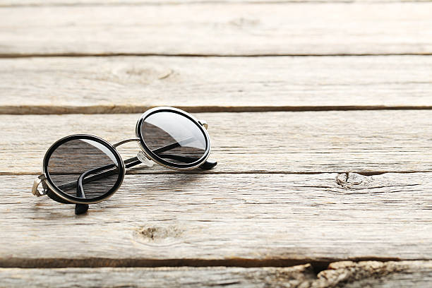 istock Black sunglasses on a grey wooden table 598156220