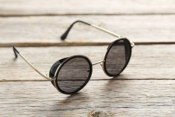 istock Black sunglasses on a grey wooden table 598156266