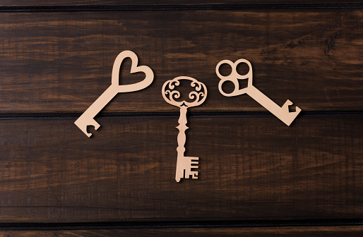 Three wooden keys on a dark background