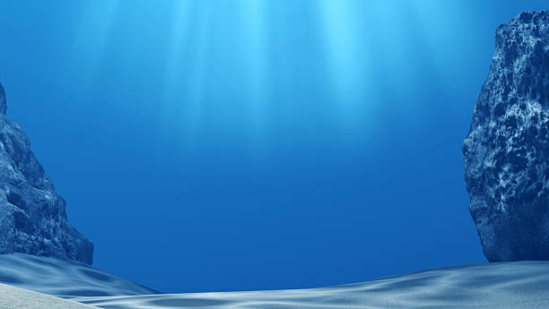 istock Underwater with sun rays and stones in deep blue sea 598156370
