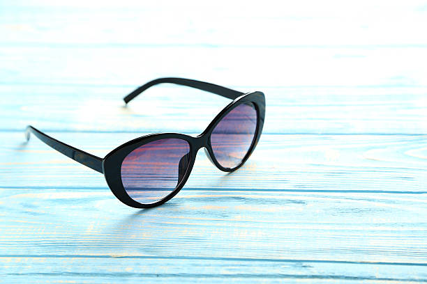 istock Black sunglasses on a blue wooden table 598156474