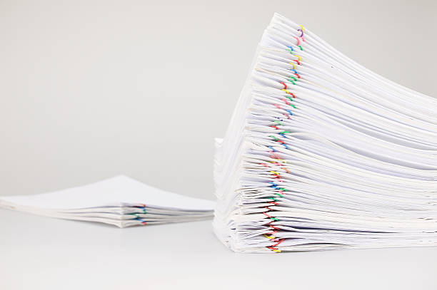 istock Pile overload paperwork with colorful paperclip with blur pile document 598162336