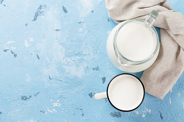 Milk jug and cup Milk jug and cup on stone table. Dairy products. Top view with copy space blue jug stock pictures, royalty-free photos & images