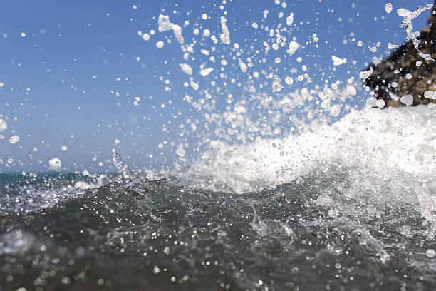 istock Sea wave splashing over the shore rocks 598165160