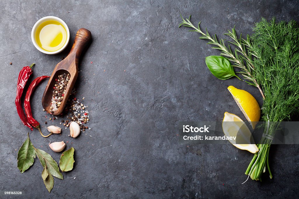 Herbs and spices Herbs and spices. Cooking ingredients. Rosemary, dill, onion, olive oil, salt and pepper. Top view over stone table with copy space for your recipe Above Stock Photo