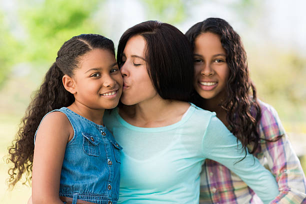 istock Loving latin mother and daughters embracing and smiling 598165654