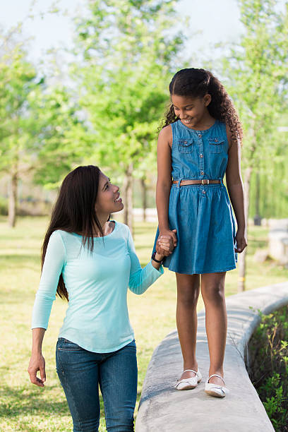 istock Happy girl walking on short wall with mother 598166466
