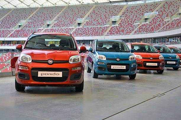 Fiat Panda vehicles Warsaw, Poland - February, 23th, 2012: The presentation of a third generation of Fiat Panda on the football stadium. This city car is one of the most popular small vehicles in Europe. The Panda is powered by petrol engines: 0.9 TwinAir/85 HP, 1.2/69 HP or diesel engine: 1.3 Multijet/75 HP. little fiat car stock pictures, royalty-free photos & images