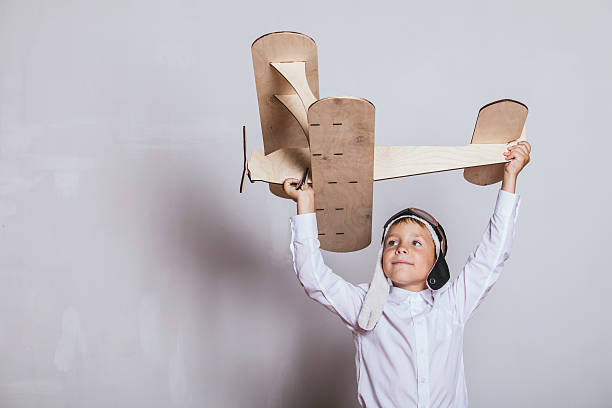 istock Boy with wooden plane model and a cap with cap 598169746
