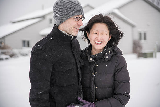 istock Multy-ethnic couple have fun outdoor under the snowfall 598170840