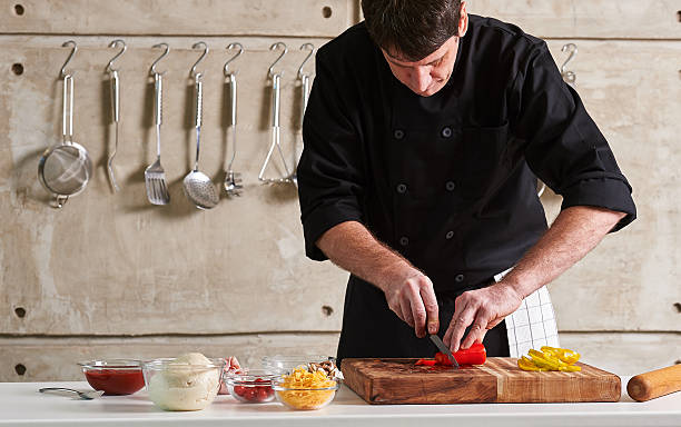 istock Restuarant hotel private chef cutting red pepper on board 598172844