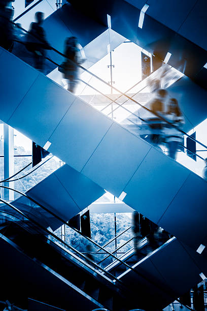 personas en la escalera mecánica del aeropuerto. desenfoque de movimiento - escalator people city blurred motion fotografías e imágenes de stock