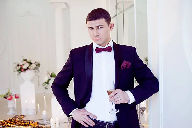 Photo of Young man at the wedding, the groom with a glass