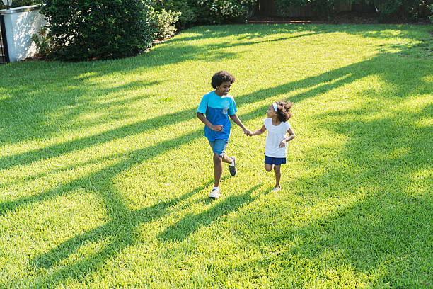 istock Mixed race brother and sister playing in park 598179044