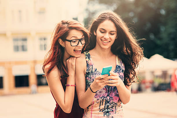 istock Two friends texting outdoor 598215282