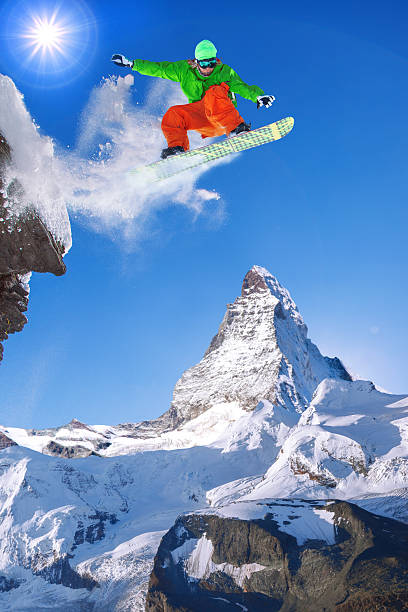 snowboarder springen gegen matterhorn-gipfel in der schweiz - zermatt stock-fotos und bilder