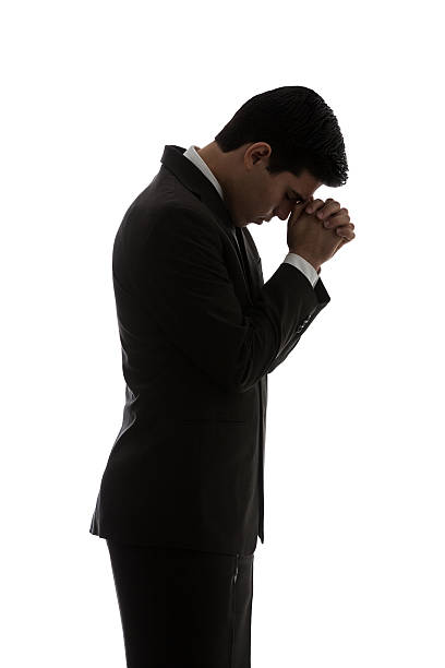 istock Young latin businessman praying 598215566