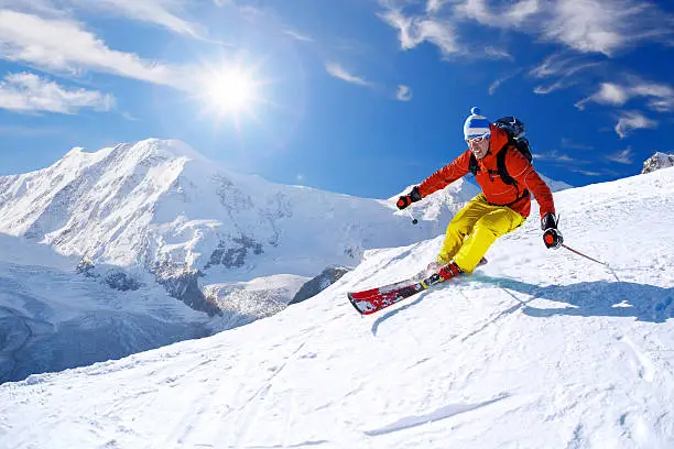 Skier skiing downhill against famous Matterhorn peak in Switzerland