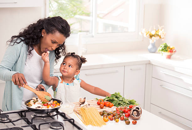 istock Mother and daughter cooking together. 598216302