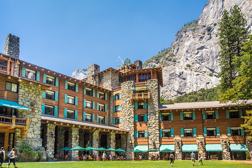Yosemite National Park, California, USA  - August 3, 2016:  Exterior view with people visible of the historic Majestic Yosemite Hotel, formerly known as Ahwahnee Hotel in Yosemite Valley.  This well visited hotel was opened in 1927. 