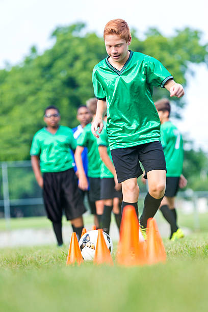 istock Teenage boy kicks soccer ball during practice 598217530