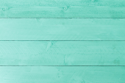 Pastel green stained wood background texture with horizontal parallel boards, woodgrain and copy space, full frame