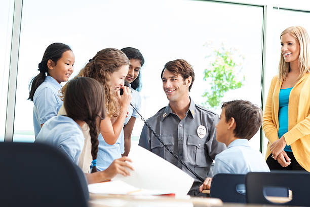 istock Security officer talks with a group of school children 598222496