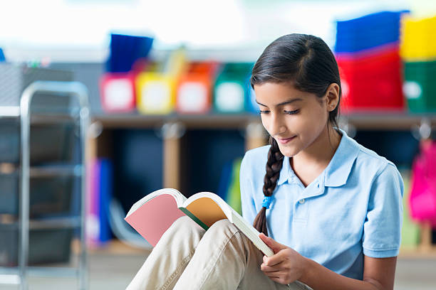 istock Focused middle school student reads book in library 598222612