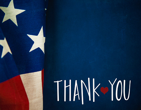 Pizarra y bandera con mensaje de agradecimiento para los veteranos de EE. UU. photo