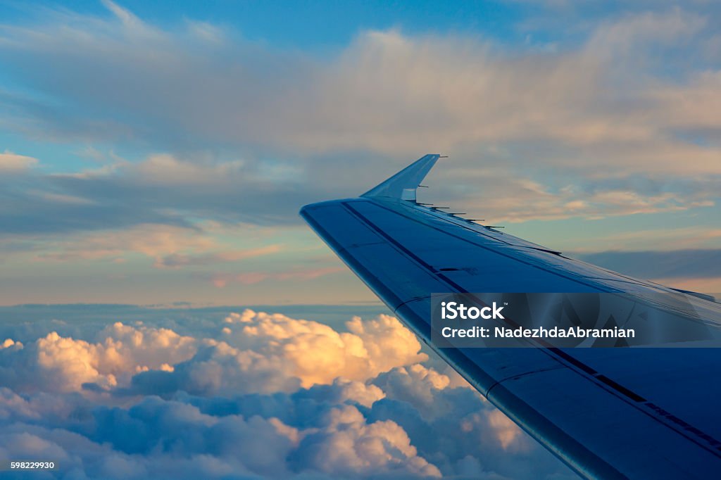 Asa do avião no fundo do céu durante o pôr do sol. - Foto de stock de Asa de aeronave royalty-free