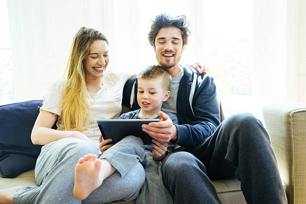 istock Cheerful Young Family Looking At Digital Tablet Together 598231194