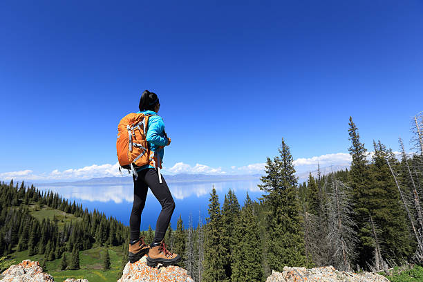 istock young woman backpacker hiking on mountain peak 598231314