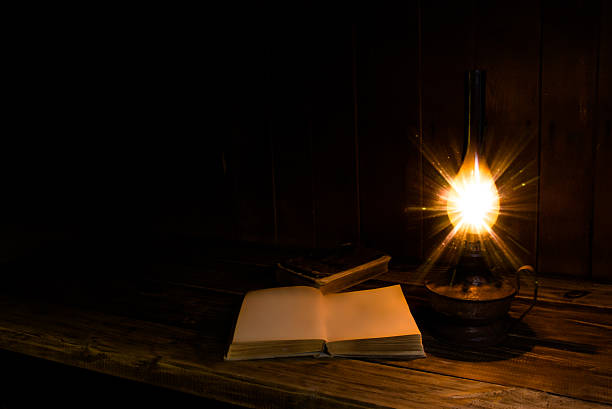 istock Old antique books with burning paraffin lamp. 598231470