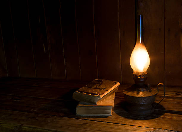 istock Old antique books with burning paraffin lamp. 598231550