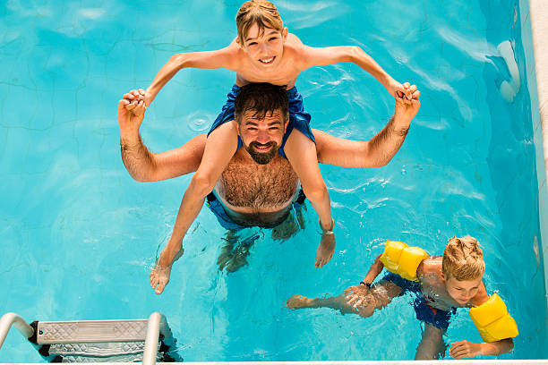 istock Dad with children in swimming pool 598234306