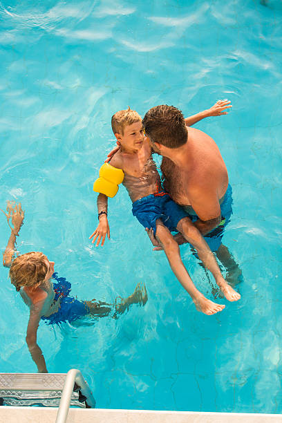 istock Father teaching son how to swim in the pool 598234326