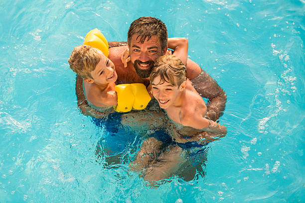 istock Dad with children in swimming pool 598234328