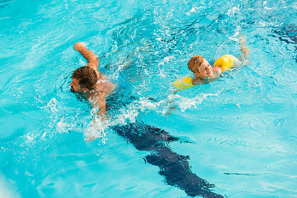 istock Father and son swimming together 598234342
