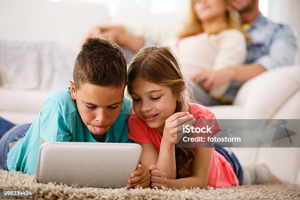 Foto de Família Relaxando Em Casa As Crianças Com Tabuleta Digital e mais fotos de stock de 10-11 Anos