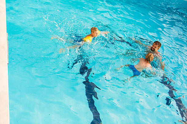 istock Father and son swimming together 598234428