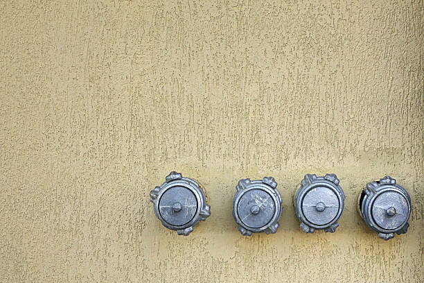 istock Valves Of Water Taps Hanging From Beige Concrete Wall 598235376