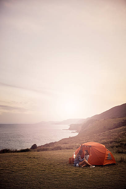 Shot of two girlfriends chatting while out camping