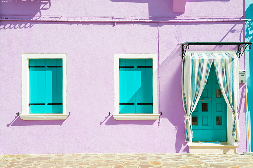 House with purple walls and turquoise windows. Colorful houses in Burano island near Venice, Italy