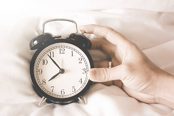 istock Alarm clock  with hands of a man holding a clock. 598239280