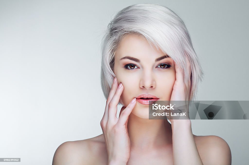 blond model with brown eyes beautiful young blond woman with brown eyes against grey studio background Blond Hair Stock Photo