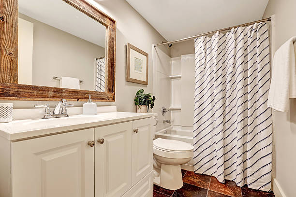 istock White Bathroom with vanity cabinet and wooden framed mirror. 598240544