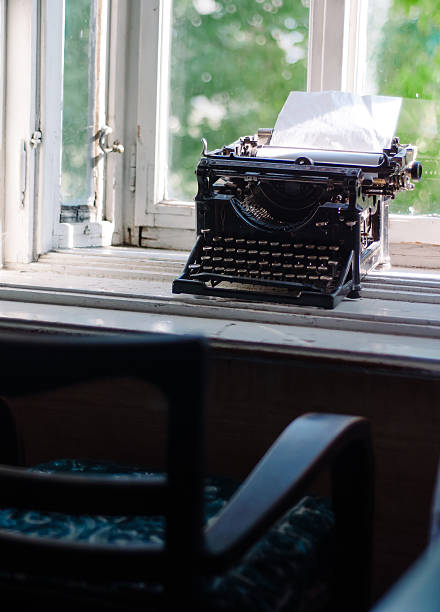 istock Vintage typewriter with blank paper on the window desk 598241654