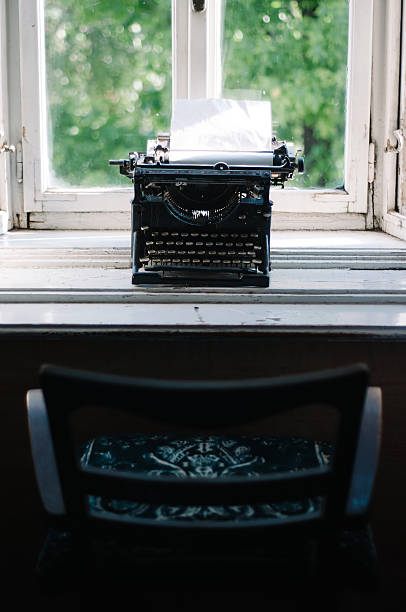 istock Vintage typewriter with blank paper on the window desk 598241724
