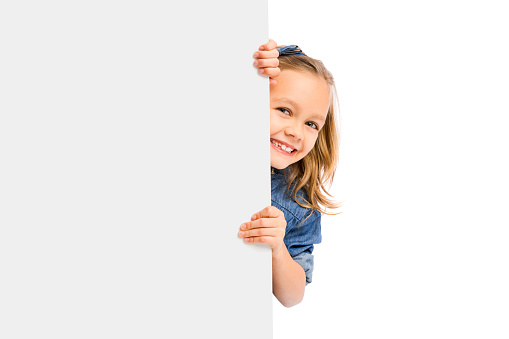 Beautiful little girl holding and showing something on a whiteboard